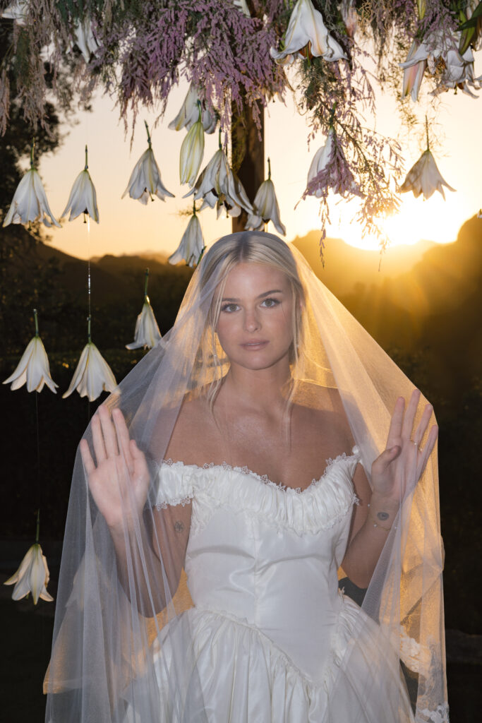 Editorial-style bridal portrait with soft golden light and Malibu mountains behind